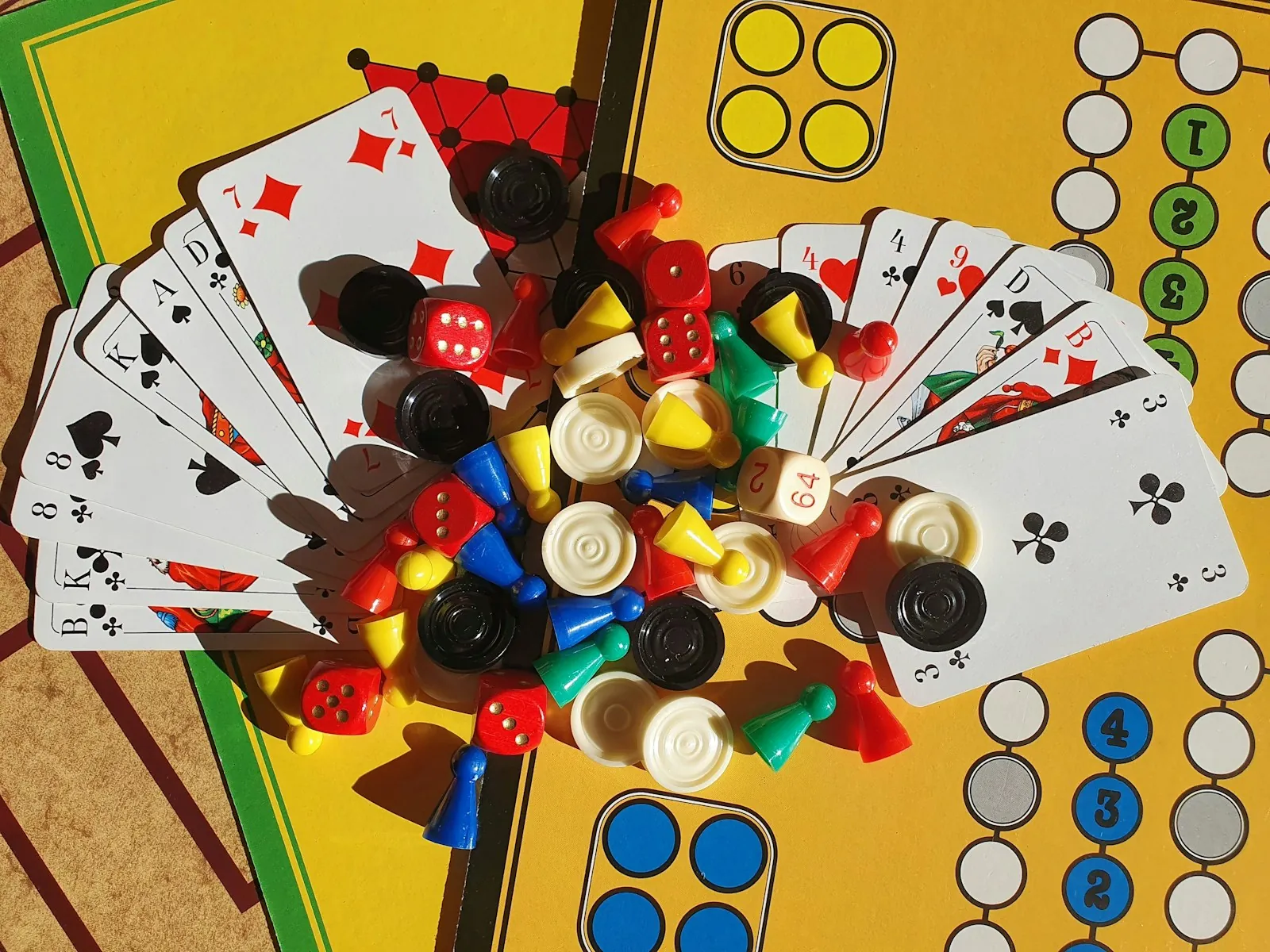 Cards dice and game pieces spread on a folding game board